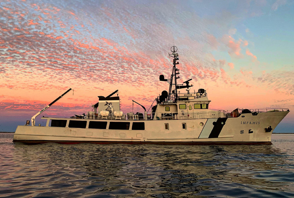 37m/120' explorer yacht INFAMIS in front of beautiful pink sky